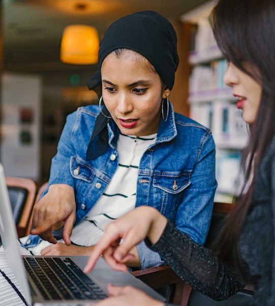 Two diverse women, one student and one teacher, working on the student's dissertation.