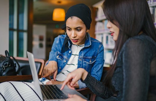 Two diverse women, one student and one teacher, working on the student's dissertation.