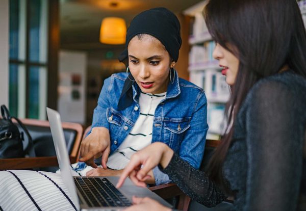 Two diverse women, one student and one teacher, working on the student's dissertation.