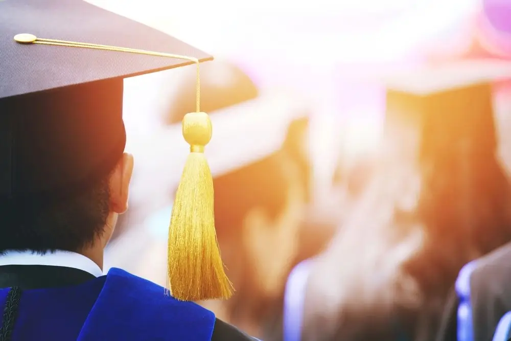 A graduate sitting at graduation receiving their phd, thanks to the help of dissertation statistics consulting.